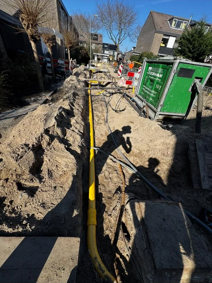 Sleuf in de straat met container voor grondafvoer
