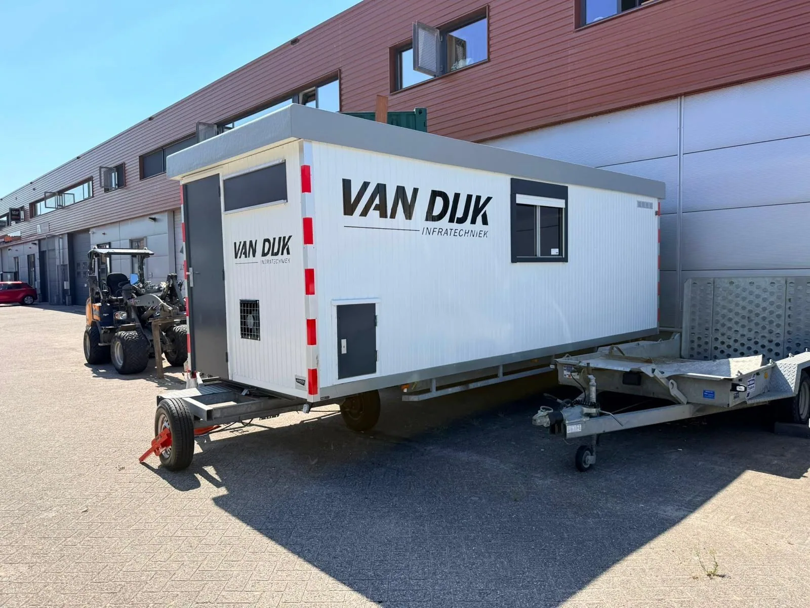 Bedrijfskeet met Van Dijk-branding op een werkterrein
